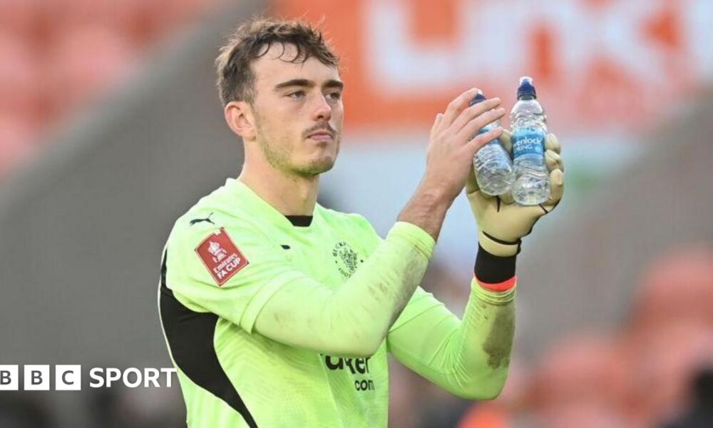 Harry Tyrer applauds fans in a Blackpool kit