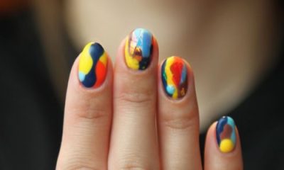 woman shows brightly colors marbled nails almost like tie-dye