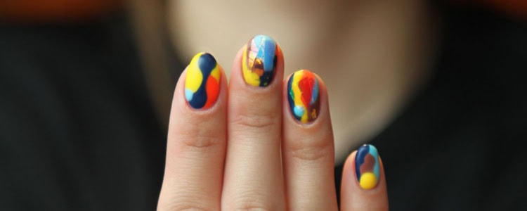 woman shows brightly colors marbled nails almost like tie-dye