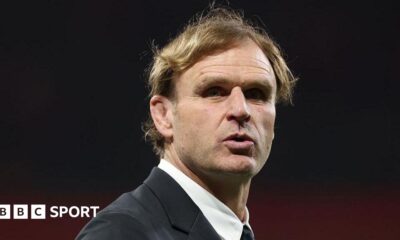 Head and shoulders view of Scott Robertson, who is wearing a white shirt with a collar and a dark suit jacket and looking slightly to his right in the direction of the camera