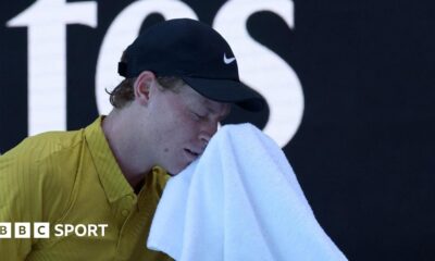 Jannik Sinner wipes his face with a towel