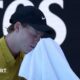 Jannik Sinner wipes his face with a towel