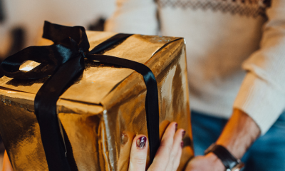 Header graphic for gifts for boyfriend's parents article with photo of someone holding a wrapped package