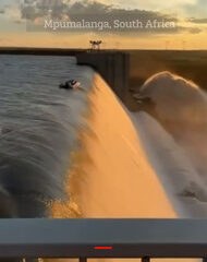 Moment four men cling to boat on edge of DAM