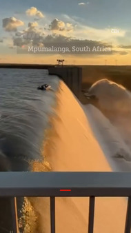 Moment four men cling to boat on edge of DAM