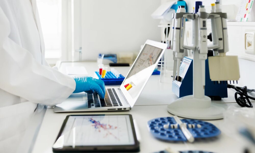 Close-Up Shot of Scientists Hands typing Data in Laptop in Laboratory