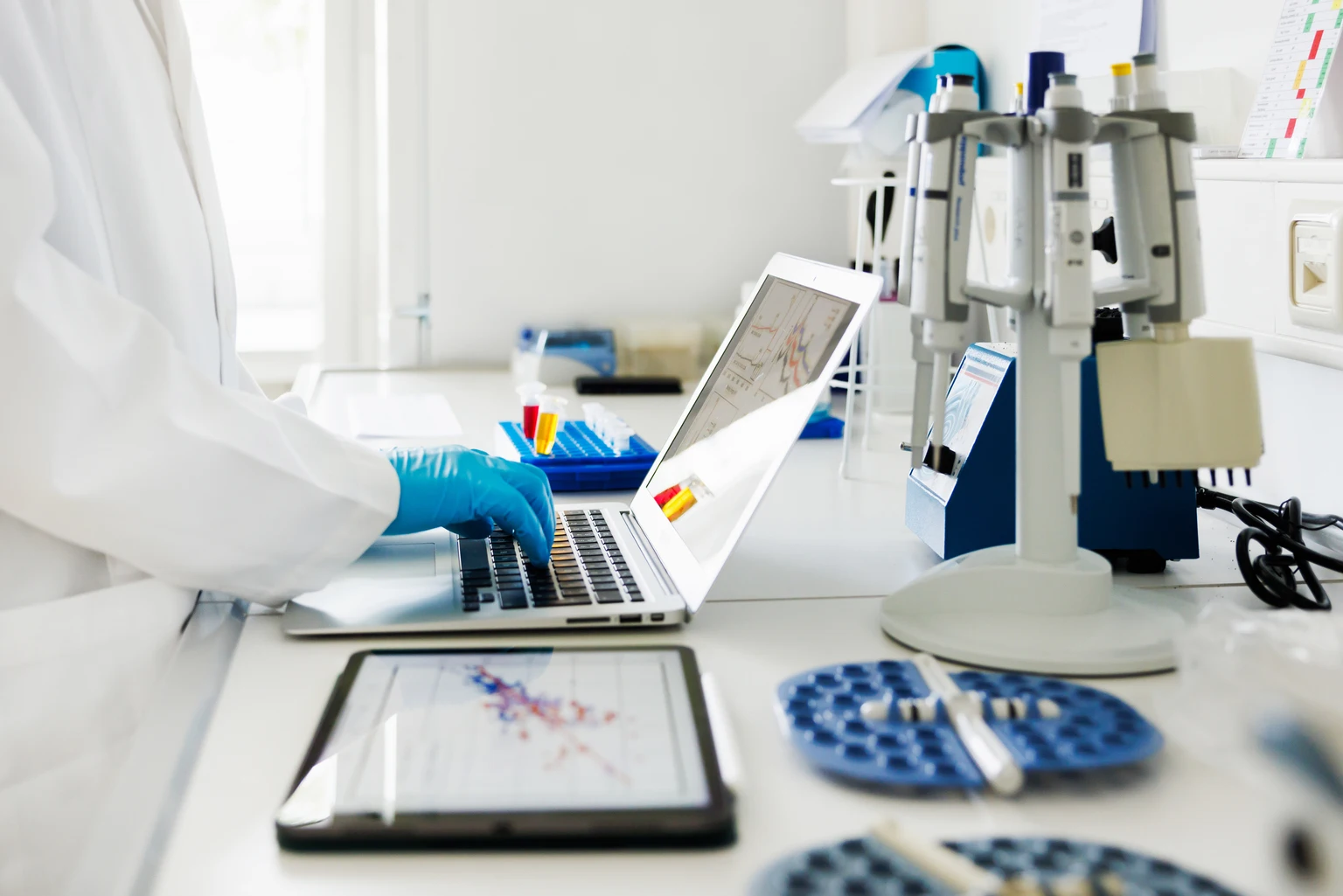 Close-Up Shot of Scientists Hands typing Data in Laptop in Laboratory