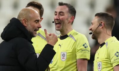 Manchester City manager Pep Guardiola talks with referee Chris Kavanagh and assistant referees