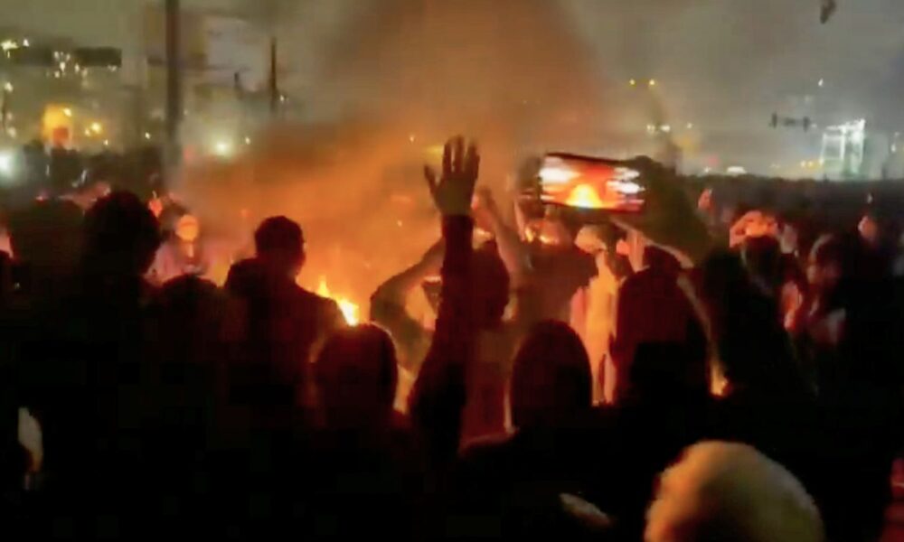 Protesters are seen in social media footage as they are dancing and cheering around a bonfire in Iran. Pic: AP