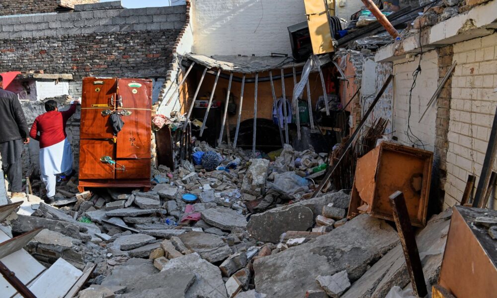 Officials survey the damage of the home hit by the explosion. Pic: AP