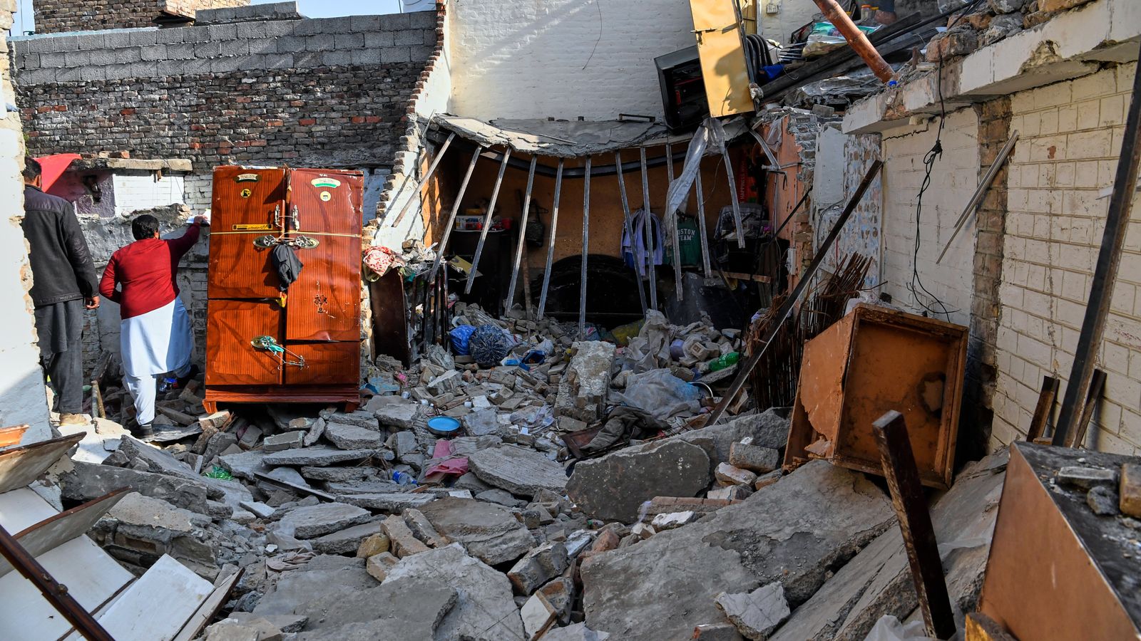 Officials survey the damage of the home hit by the explosion. Pic: AP