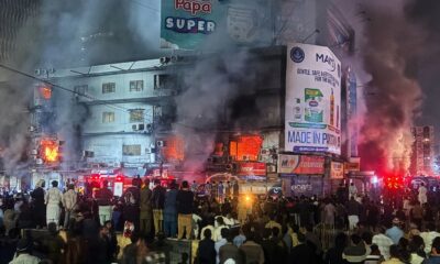 People watch as firefighters battle the fire in Karachi, Pakistan. Pic: AP