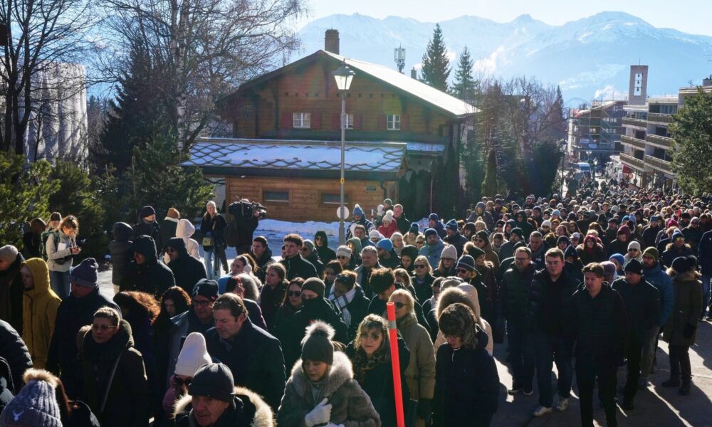 Hundreds of people walked in silence to the site of the tragedy in the Swiss ski resort of Crans-Montana. Pic: AP