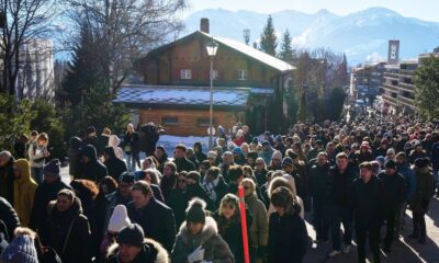 Hundreds of people walked in silence to the site of the tragedy in the Swiss ski resort of Crans-Montana. Pic: AP