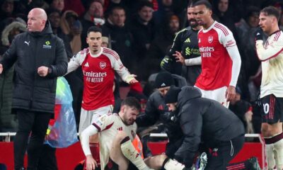 Conor Bradley of Liverpool is treated for injury as Gabriel Martinelli and Gabriel Magalhaes of Arsenal look on