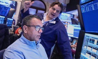 Wall Street flirts with a record as stocks zigzag following mixed profit reports