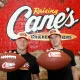 Christian and Luke McCaffrey holding footballs at Raising Cane's