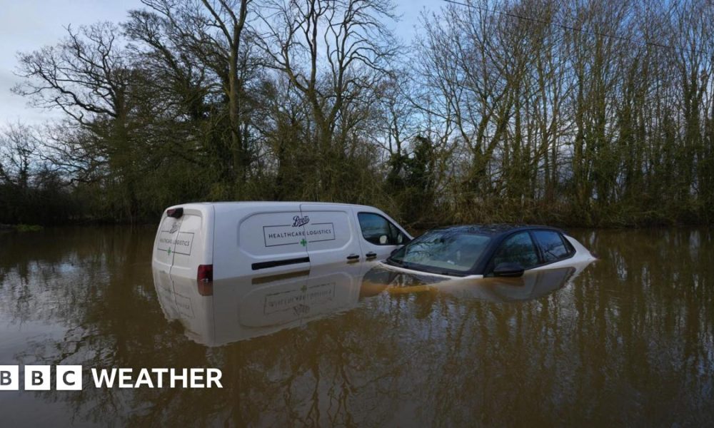 A van and a car left abandoned in a flooded ford in Watery Gate Lane, Thurlaston, Leicestershire. The water rises to the vehicles' front windows.