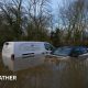 A van and a car left abandoned in a flooded ford in Watery Gate Lane, Thurlaston, Leicestershire. The water rises to the vehicles' front windows.