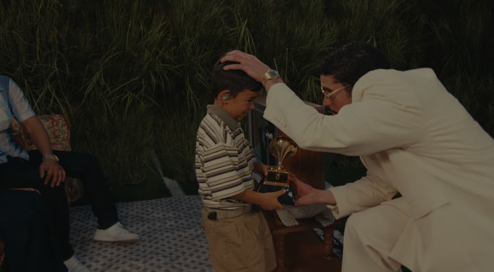 Bad Bunny presents a child performer with one of his Grammys during Sunday night's Super Bowl Halftime Show