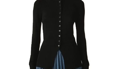 a woman wearing a black buttoned cardigan and blue pleated skirt