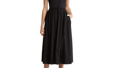 A woman wearing a black midi dress and black strappy heels