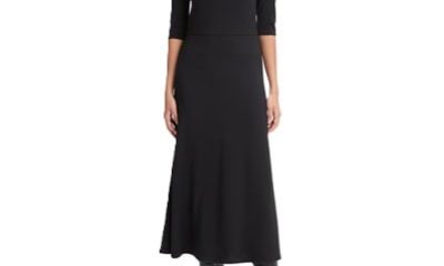 A woman wearing a black turtleneck midi dress and black tall boots