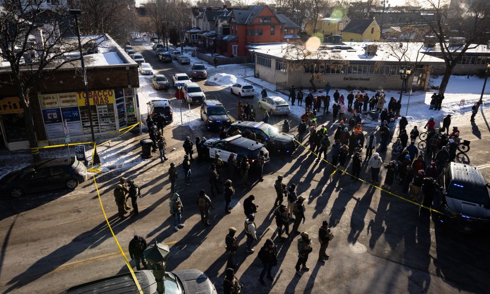 People gather at the intersection of 27th Street and Nicollet Avenue, a block from the shooting.