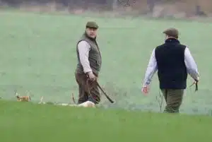 Huntsman Saunders with his pack of beagles and hunting horn, looking upset.