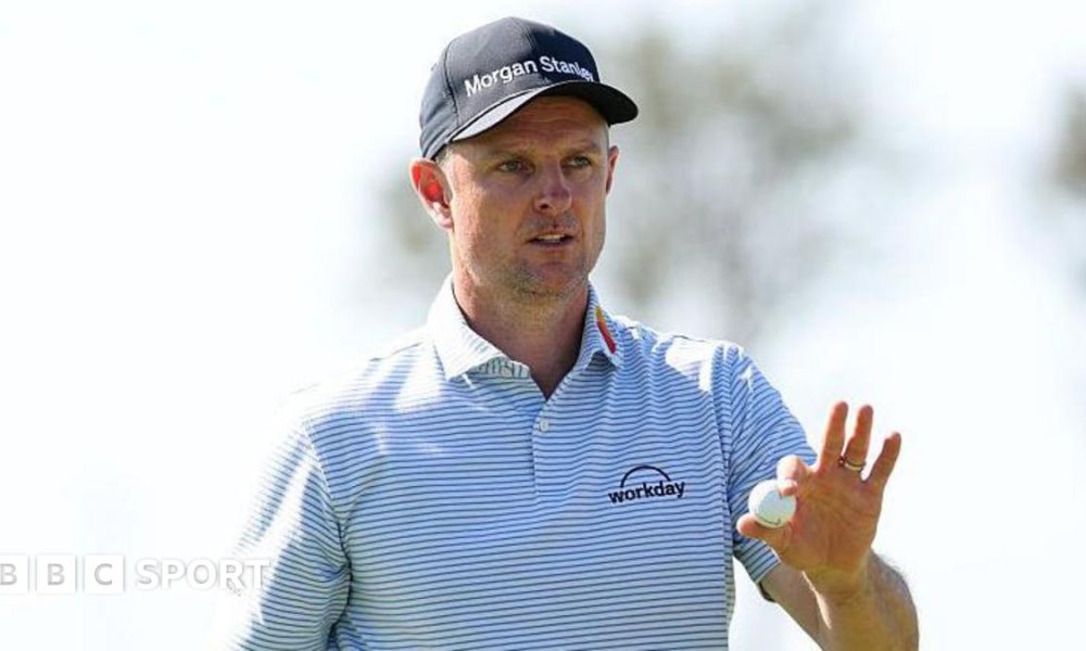 Justin Rose holds a golf ball up