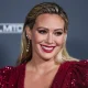 Hilary Duff wearing an Osman dress and Rahamoniv jewelry while wearing shoes and carrying a clutch by Jimmy Choo arrives at the Baby2Baby 10-Year Gala 2021