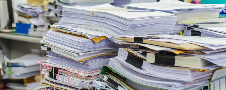 papers piled up on messy desk, I think this worker has an unreasonable workload