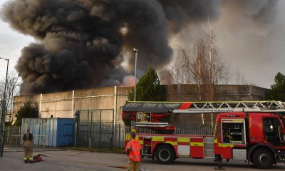 Huge fire engulfs scrap yard as plumes of smoke 'seen for miles' and people urged to avoid the area