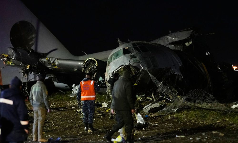 People at the scene where a plane crashed in El Alto, Bolivia. Pic: AP Photo/Juan Karita