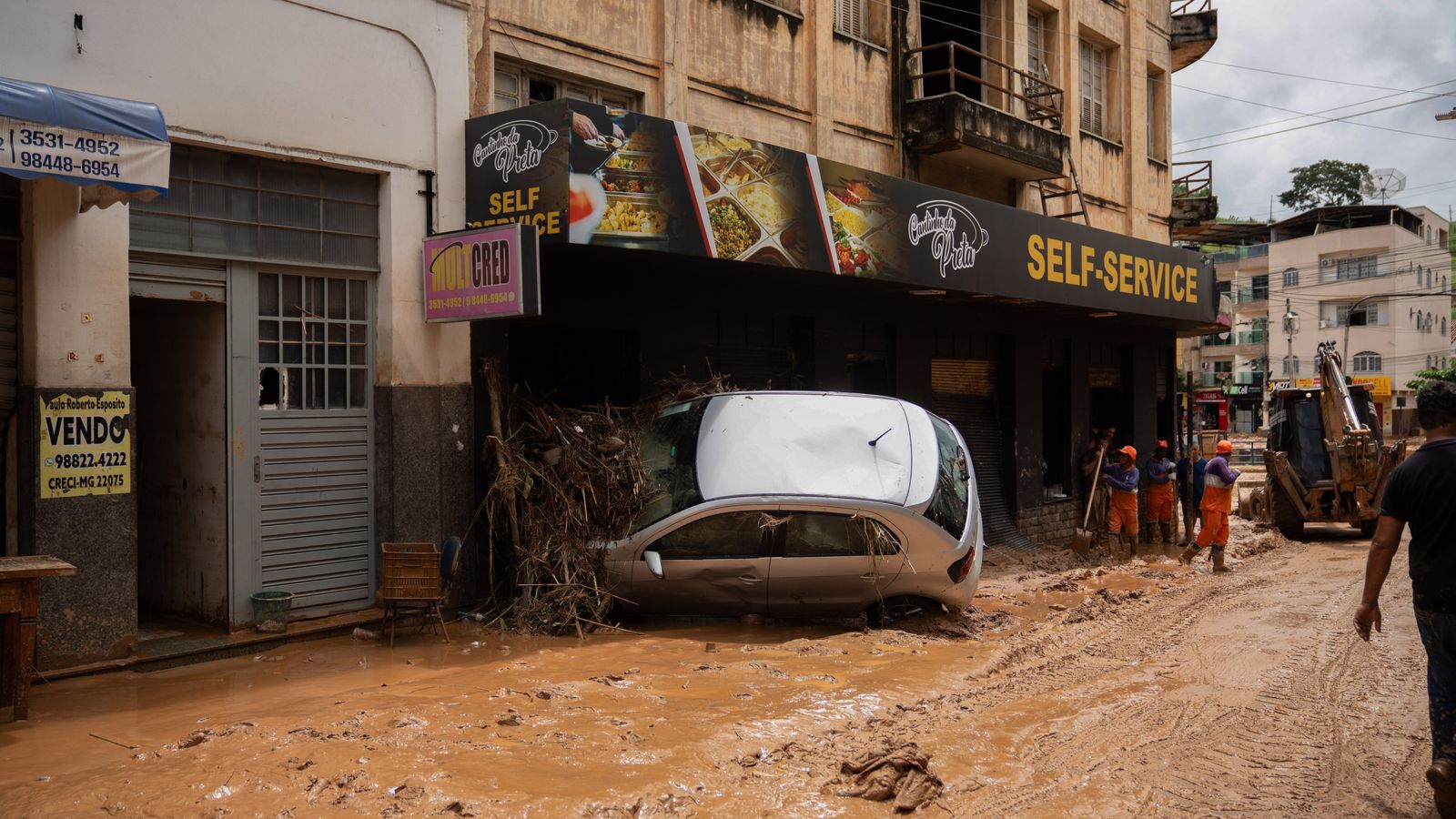 A car is stuck in a snack store after heavy rainfall in south-eastern Brazil. Pic: dpa/AP