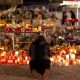 A woman lights a candle at a memorial outside the Le Constellation bar. Pic: Reuters