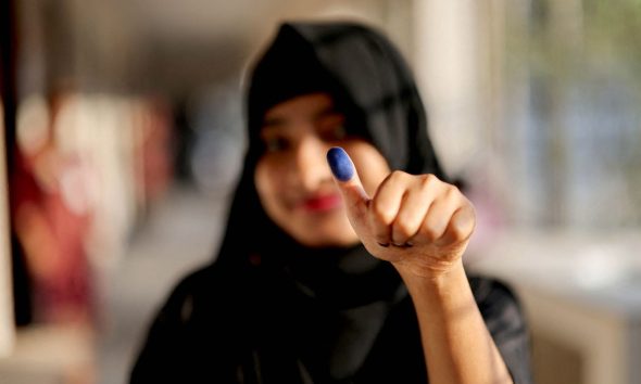 A woman shows her thumb with an ink mark after casting her vote in Dhaka, Bangladesh. Pic: Reuters