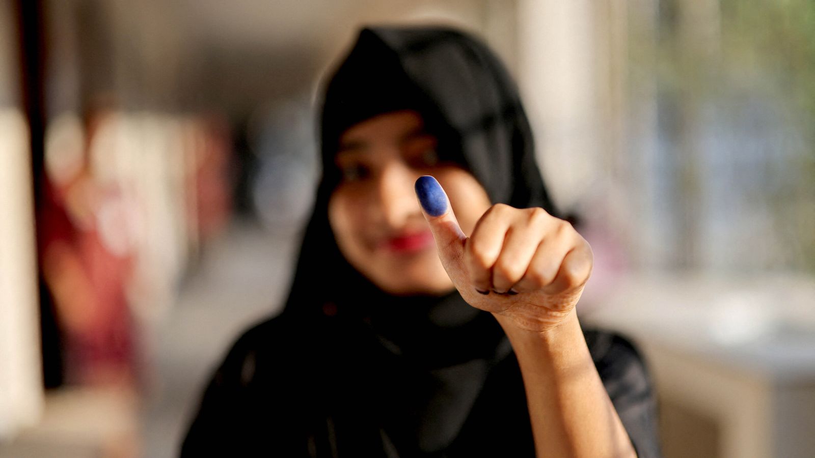 A woman shows her thumb with an ink mark after casting her vote in Dhaka, Bangladesh. Pic: Reuters