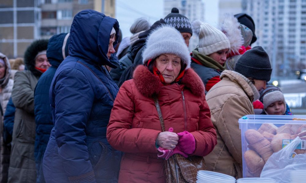 People left without power queuing for free hot meals in Kyiv. Pic: AP