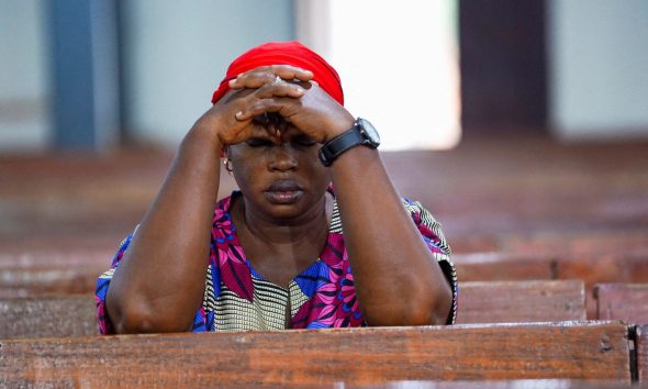 A woman prays at church in Minna, Nigeria, after a separate incident last year which saw scores of people kidnapped. The country has been rocked by sectarian violence in recent years. Pic: Reuters