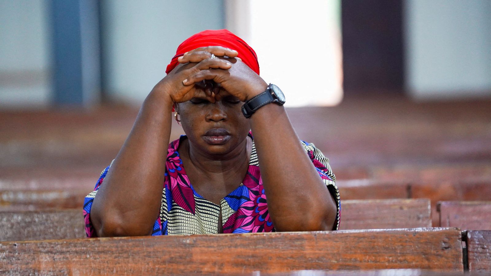A woman prays at church in Minna, Nigeria, after a separate incident last year which saw scores of people kidnapped. The country has been rocked by sectarian violence in recent years. Pic: Reuters