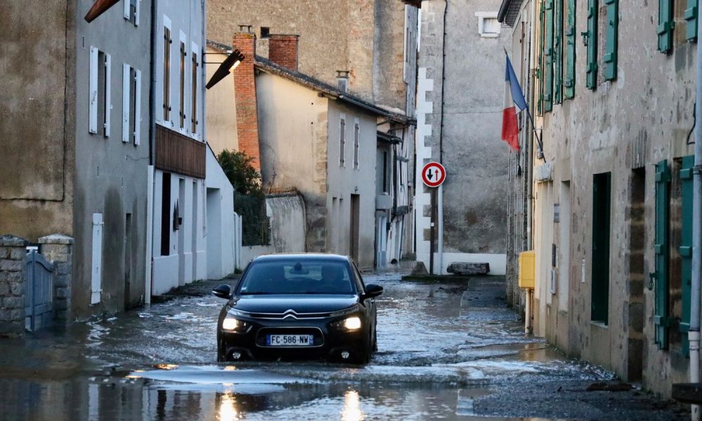 A car drives through a flooded street of Saint-Germain de Confolens as severe flooding hits western France. Pic: AP