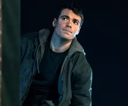 Gabriel Basso as Peter Sutherland outside next to a brick wall in Season 2 of The Night Agent