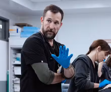 Dr. Robby holding up a hand in the ER