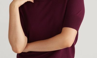 A woman wearing a short-sleeve purple sweater and matching pants