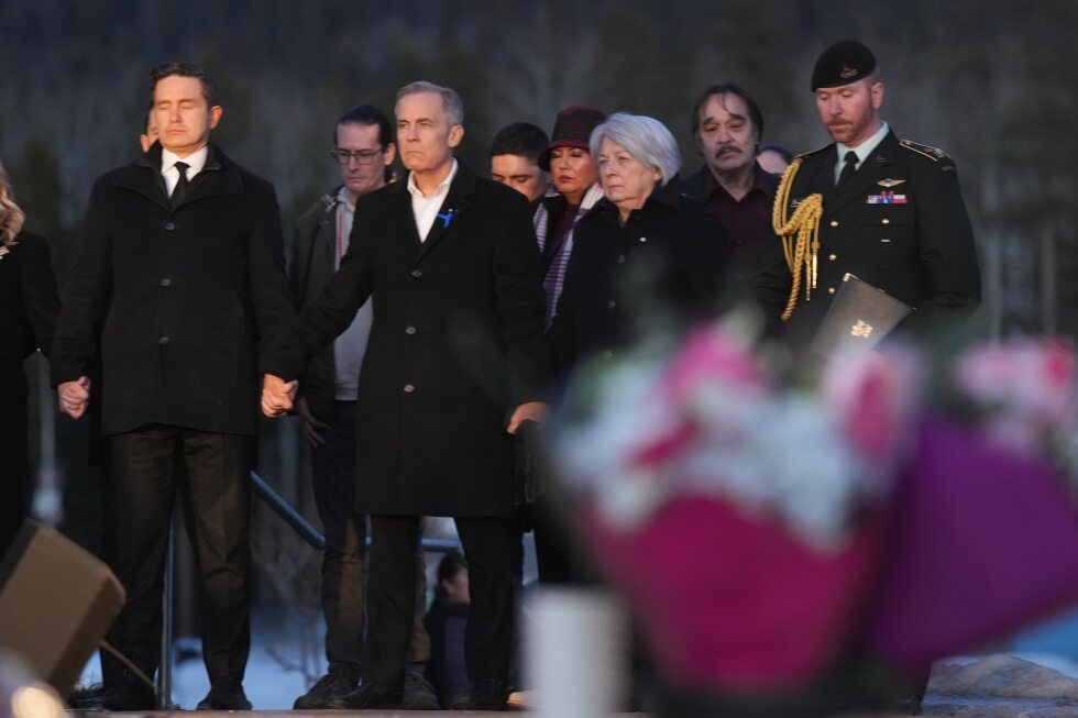 Prime Minister Carney and Canada's main opposition leader hold hands during school shooting vigil