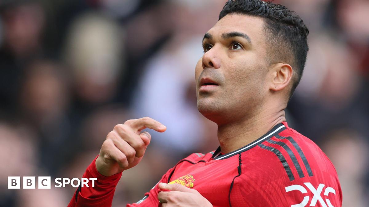 Manchester United midfielder Casemiro points to the club badge on his red shirt