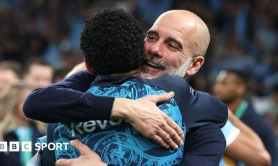 Pep Guardiola hugs his players
