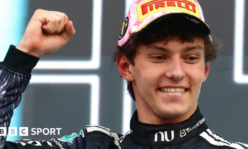Kimi Antonelli smiles and clenches his fist in celebration on the podium after winning the Japanese Grand Prix