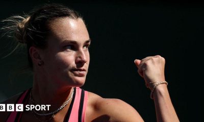 Close-up of Aryna Sabalenka who is raising her fist to celebrate winning a point.